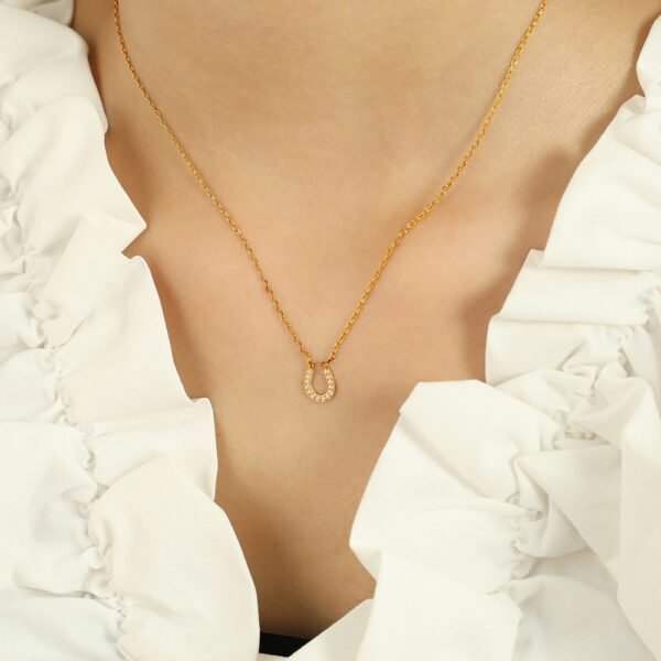 Pavé Horseshoe Pendant Necklace product image 4 Pavé horseshoe pendant necklace worn at the collarbone with a neutral top