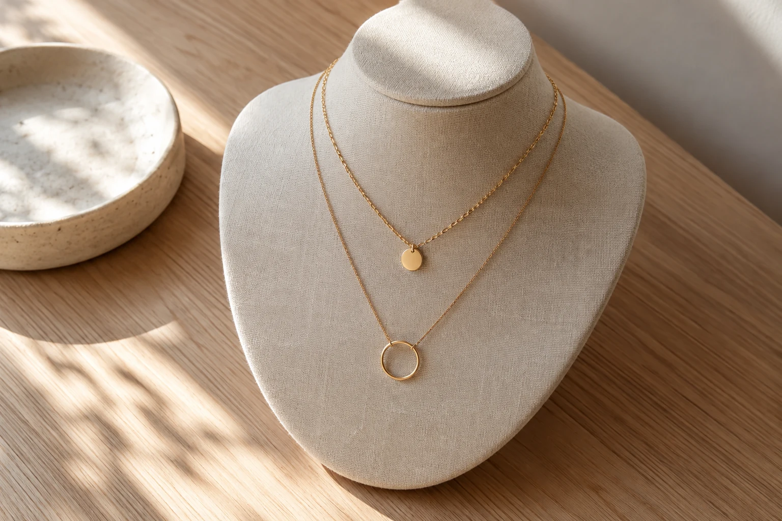 Two generic necklaces at different levels on a plain bust